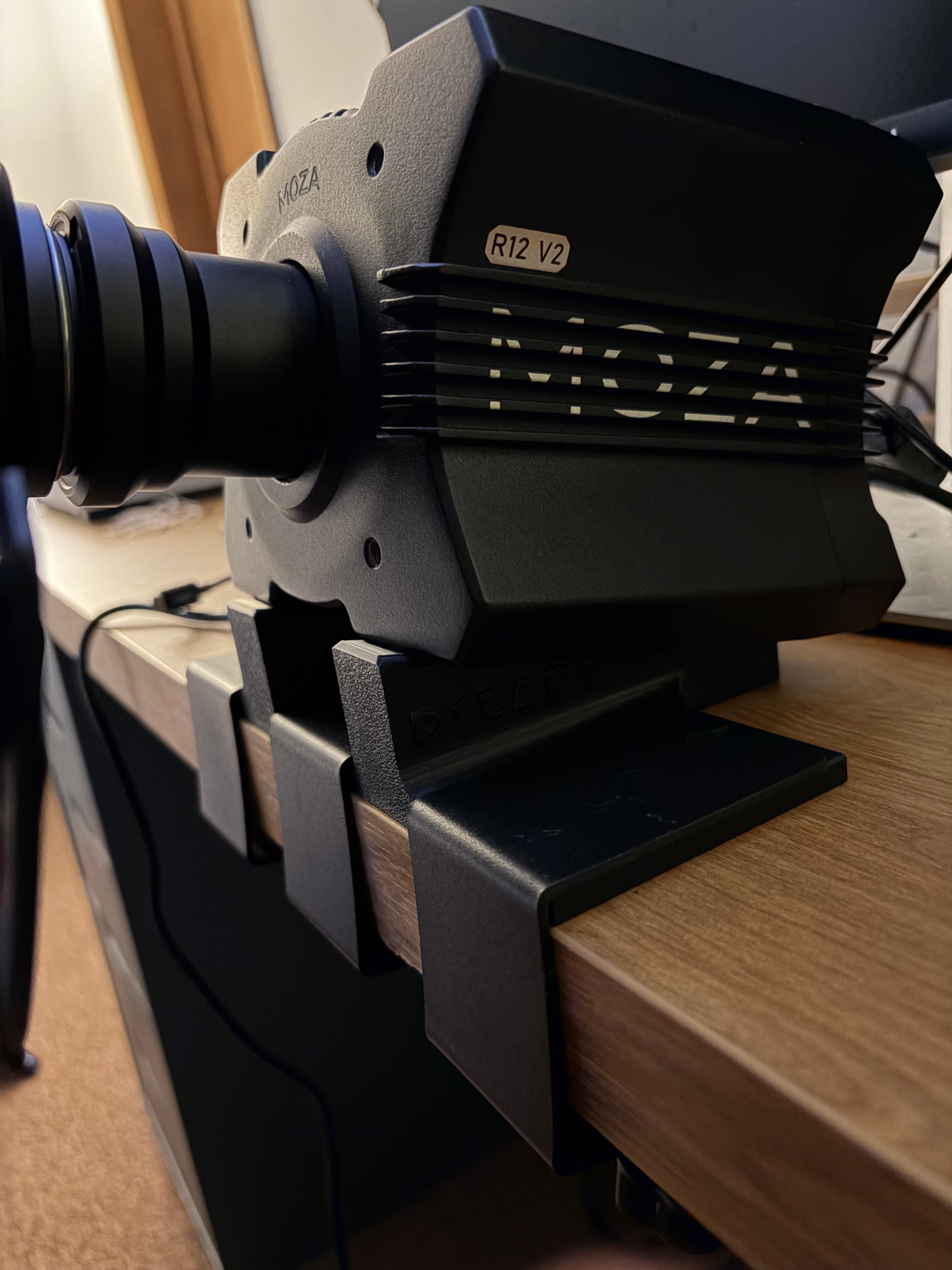 A 3D printed adapter clamped to the table with c clamps
